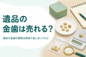古い缶と小皿の上の小さな金色の金属片、小袋、はかり、「遺品の金歯は売れる？」の文字