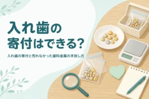 テーブルの上の金属片の小袋と紙箱、メモ用紙、「入れ歯の寄付はできる？」の文字