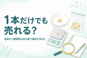 小皿の上の小さな金色の金属片と小袋、はかり、「1本だけでも売れる？」の文字